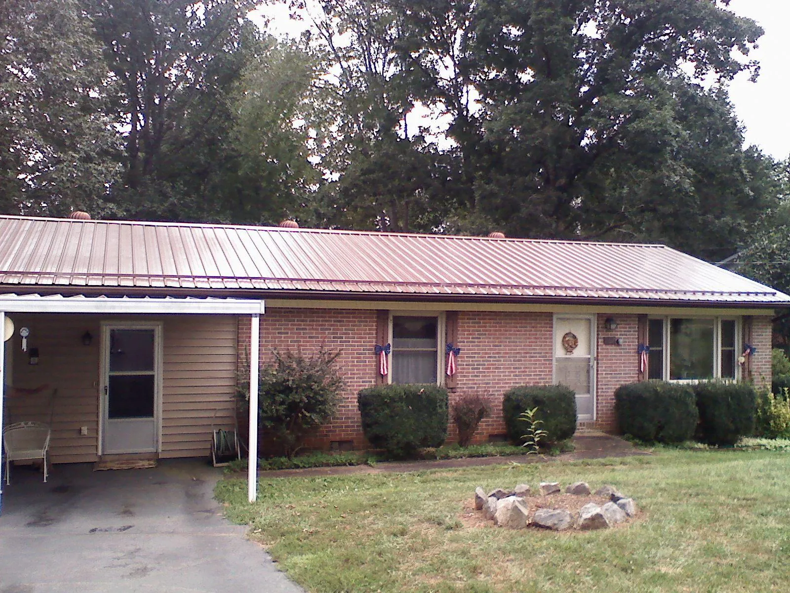 Bronze metal roof and carport on a brick ranch home — Roof Repair work by our crew in Ashford